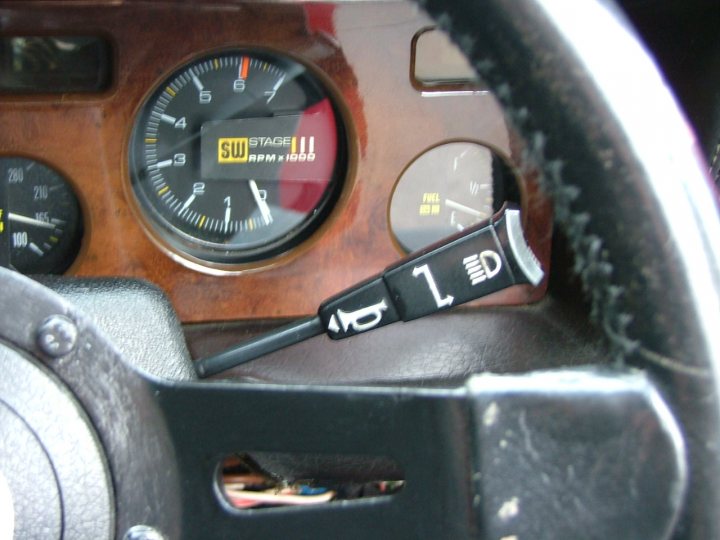 1981 280i Stalk controls - Page 1 - Wedges - PistonHeads - The image shows a drivers' side instrument cluster on the upper part of a vehicle's steering column. There are two gauges visible: a speedometer and a tachometer. The speedometer indicates that the vehicle's speed is at 1, and the tachometer shows the engine's RPM at zero. A gearshift lever, which is black plastic and misses a number, is prominently placed to the right of the gauges.