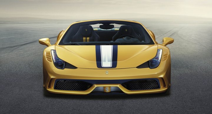 speciale spider is here  - Page 1 - Ferrari V8 - PistonHeads - The image showcases a luxurious sports car in motion on a road. The vehicle is painted in a striking yellow color with contrasting blue stripes running down the side, accentuating its sleek design. The long hood and the low and wide profile of the car suggest its high-performance capabilities. The car moves from left to right across the image, indicating a scene of speed and style. The road leading to a blurred horizon adds a sense of adventure and freedom to the image.