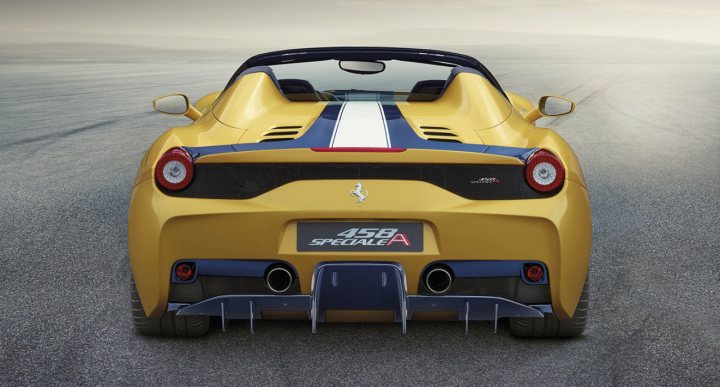 speciale spider is here  - Page 1 - Ferrari V8 - PistonHeads - The image showcases a vibrant yellow sports car with a blue and white racing stripe, quickly moving on an asphalt road that curves through a blurred landscape. The car's angular design and the shiny metal of the rims contribute to its sporty and dynamic appearance. The car's speed and the swiftness of the wind create a sense of movement blurring the scenery in the background.