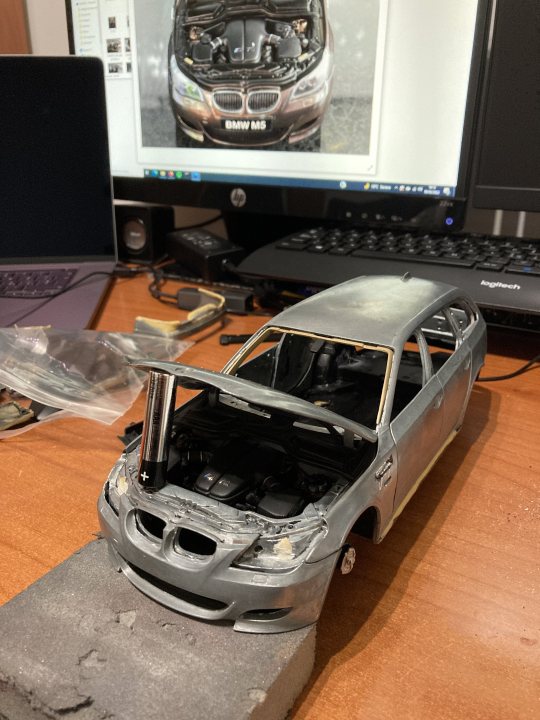 A car is parked on the side of the road - The image presents a scene where a car has been disassembled to the point that its parts are scattered on a desk. The car, which appears to be an SUV, is missing its roof and hood, revealing the intricate mechanical components within. A computer screen in the background shows the same car in an undamaged state, indicating that this is not a physical vehicle but a model or representation of one. Despite the chaos on the desk, there's an air of precision and attention to detail. The image exudes a sense of curiosity and exploration, as if inviting viewers to delve into the world of automotive engineering.