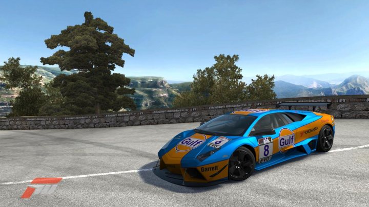 Forza Pistonheads Paint - The image depicts a vibrant and speedy scene featuring a tail-dragg racing car parked on a track. The car's predominant color is a dynamic blend of blue and orange, complementing the energetic atmosphere of the scene. The car proudly displays the GULF brand, aXR PE00, serial number 8, and the Gulf racing team logo, suggesting it's a realistic GULF racing car replica.

The track is nestled amidst stunning nature, with mountains forming a breathtaking backdrop under a clear blue sky. To the right, there's a stone wall, adding a touch of rustic charm to this high-octane setting. The contrast between the thrilling race machine and the serene landscape creates a visually captivating image that echoes an 'GTMeets Nature' theme.