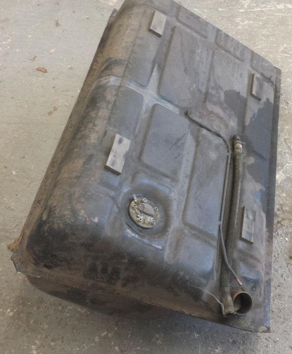 A close up of a pair of scissors - Pistonheads - The image shows an old, rusted, black metal box lying on its side on a concrete surface. The top of the box is open, exposing its inner workings. There's a visible key lock on the front side of the box. The box has various mechanical parts and bolts, indicating it might be the cover of an engine or a similar type of machinery.