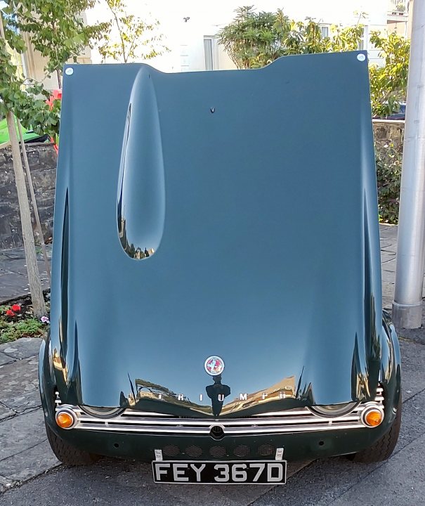 A car with a surfboard strapped to the back - Pistonheads - The image showcases a classic car, which is prominently displayed and occupies a large portion of the frame. Its body color is a deep blue, contrasting with its shiny silver roof. The car has distinctive design elements such as round headlights and a chrome grille, which are characteristic features of vintage models. It appears to be parked outside, as evidenced by a tree visible in the background. Additionally, there's a license plate on the car, indicating that it is registered for use on public roads.