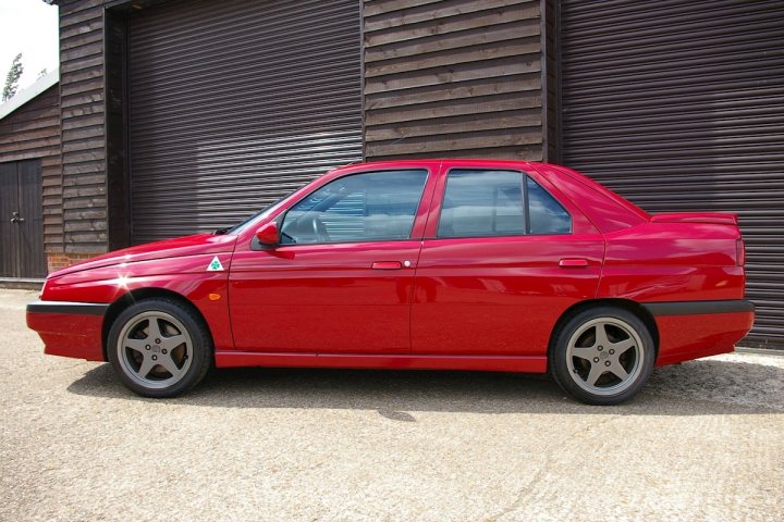 A red car is parked in a parking lot