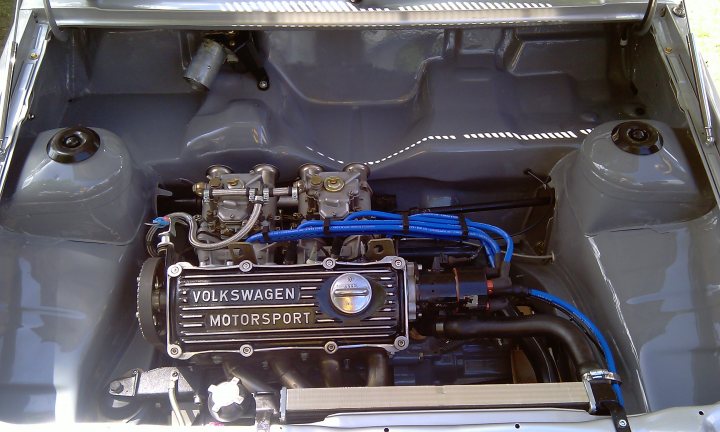 Cars On The Green - Photo Thread - Page 1 - East Anglia - PistonHeads - The image captures the engine bay of a Volkswagen car, with a prominent motor labeled "Volkswagen MOTORSPORT." The motor, a silver-colored, professional-looking unit, is the key focus within a metallic engine compartment. The motor is surrounded by a complex array of tubes and wires, indicative of the car's advanced engineering. Adding to the industrial look is a plastic bag containing engine oil, a common sight in mechanic's settings. The overall scene provides a detailed view into the workings of a vehicles' powerhouse.