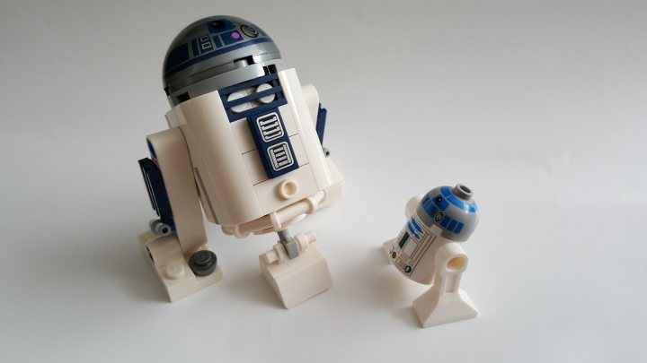 A close up of a nintendo wii game system - The image showcases two LEGO models representing the Millennium Falcon and R2-D2 from the "Star Wars" franchise. They sit on a light gray background, with the R2-D2 model slightly in front of the larger Millennium Falcon model. Both models are constructed from white LEGO pieces and display the iconic designs associated with the characters. The overall scene is a celebration of "Star Wars" culture and the joy of LEGO building. The models appear to be sturdy and detailed, reflecting the precision and craftsmanship of LEGO construction.