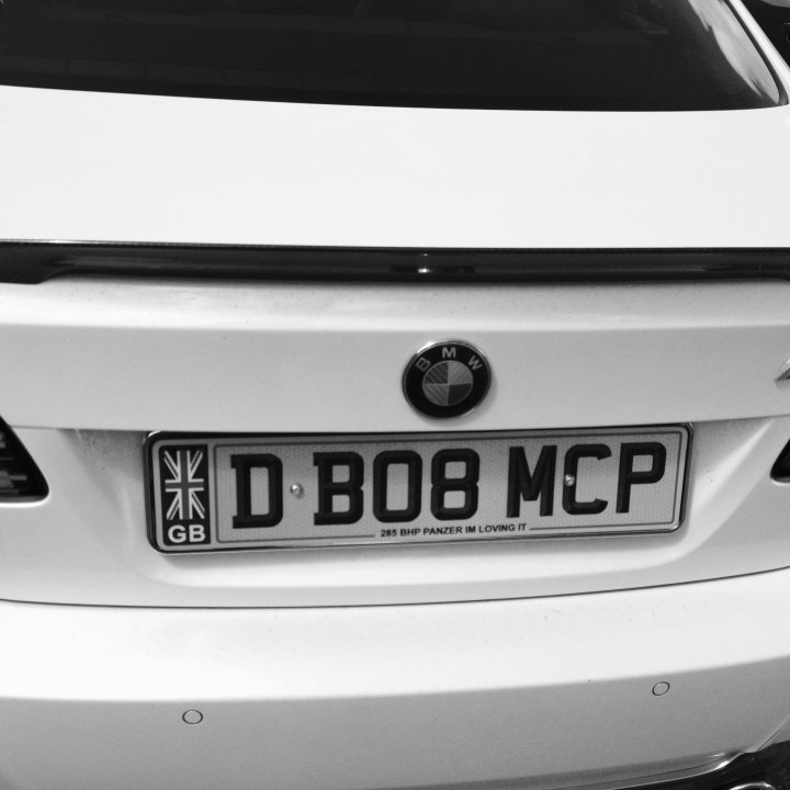 What crappy personalised plates have you seen recently? - Page 436 - General Gassing - PistonHeads - The image shows the back side of a white car. On the rear bumper, there is a license plate, which reads "D BO8 MCV." The car also has a logo indicative of BMW. The license plate is predominantly visible with the edge of the back window visible at the top of the image. The background is dimly lit, providing a stark contrast to the brightly lit car in the foreground. The vehicle appears to be a sedan, given its overall shape and the placement of the bumper and license plate.