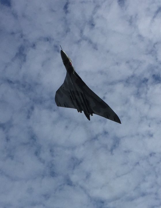 Pistonheads - The image captures a moment of a fighter jet soaring through a sky filled with fluffy white clouds. The jet, painted in a dark color with lighter accents, is caught mid-flight, its nose pointed upwards in the direction of its flight path. The jet appears to be a military machine, designed for speed and agility. The cloudy sky forms a dynamic backdrop to the aircraft, adding a sense of height and scale to the image. The contrast between the dark jet and the lighter sky provides a visually striking element to the scene.