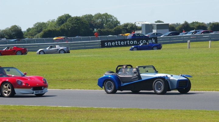 Snetterton Lotus Festival 25/26 June - Page 1 - General Lotus Stuff - PistonHeads - The image showcases a high-speed action on a race track. Numerous racing cars are captured in the midst of their performance. They appear to be in the midst of an intense race, likely a rally-race event given the vehicles and the setting. There is a sense of competition and speed. The cars are spread out across the frame, creating a dynamic and exciting scene of racing.