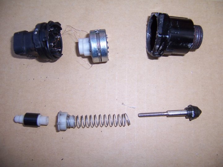 Solved Pistonheads Shunting - The image depicts three broken shock absorbers lying on a piece of cardboard. The parts are jumbled, with various metal components tangled together. One of the components appears to have a circular shape, potentially from a core piece of the shock absorber, while the other piece looks like it might be from the lower mounting place. There are no visible threads or spring elements visible in the photo. The parts seem to be mechanical in nature and possibly used for automotive or suspension purposes.