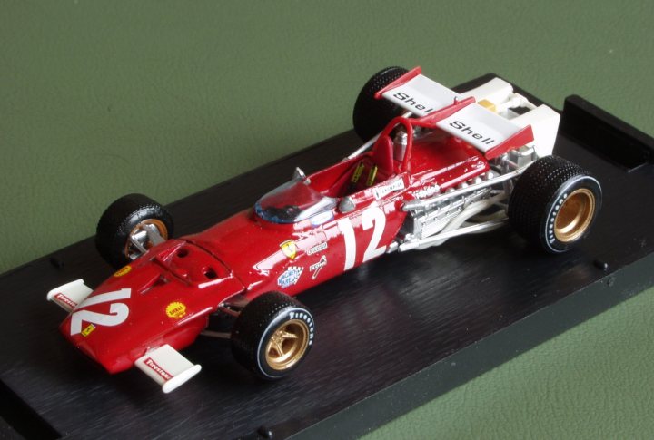 Pistonheads Collection - The image showcases a vibrant, toy-racing car prominently positioned on a circular black base. The car, painted in striking red and white, is adorned with the #12, suggesting a racing team or driver's number. It features a shiny gold nose, adding to its racing appeal. The car is rear-wheel drive, indicated by the visible set of rear tires. The base on which the car sits is described as black, serving as a practical contrast to the car's colorful design. This image captures the captivating charm of toy racing cars, a scene that invokes nostalgia and the thrill of the race. The intricate details of the car, from its numbered chassis to its gold nose, contribute to a scene that exudes competitiveness and fun.