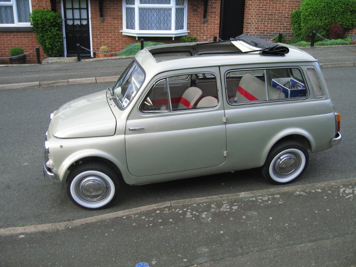 Fiat 500 - Page 1 - Readers' Cars - PistonHeads - This image showcases a charming little Volkswagen Beetle, parked on the side of a street. The car, painted in a pristine shade of gray, has a white roof and white license plates. The vehicle has also been neatly accessorized with two luggage racks on top, equipped to stand out against the backdrop of the city. The pavement on which the car is parked appears to be in a residential area, providing a calm and serene setting. The Volkswagen Beetle's classic silhouette and accessorized roof racks make it a distinctive and eye-catching sight.