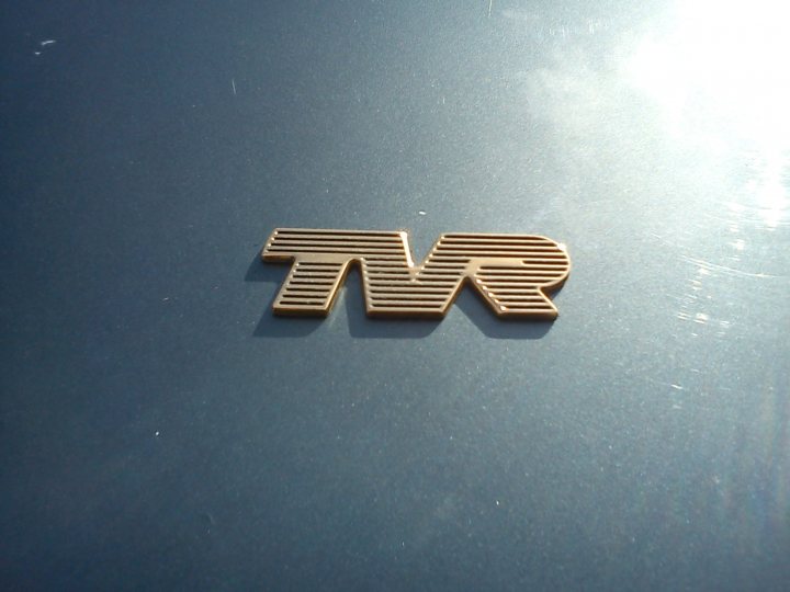 What's happening in your garage this weekend ? - Page 112 - Wedges - PistonHeads - The image shows an embossed logo of "Tvrs" on a sleek, dark blue surface. The logo features a stylized initial 'T' below a rectangular logo with the letters "vr" intertwined. A background with streaks of light adds a dynamic element to the composition, suggesting motion or a digital, high-tech theme. The material appears to be a reflective surface, as indicated by the shimmering reflections working across the image.