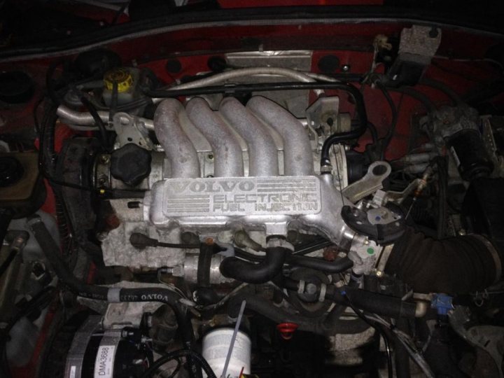 A close up of a motorcycle parked in a garage - Pistonheads - The image shows a close-up view of an engine bay, focusing on the engine. The engine is the main subject of the image. It appears to be made of metal, and the colors of the engine are a mix of red and silver, possibly from the paint and the metallic parts. There are various components visible, such as a water pump, a motor, and possibly some other mechanical parts. The words "EATON" and "106" can be seen, likely indicating the manufacturer of the engine or the specific model of the vehicle.