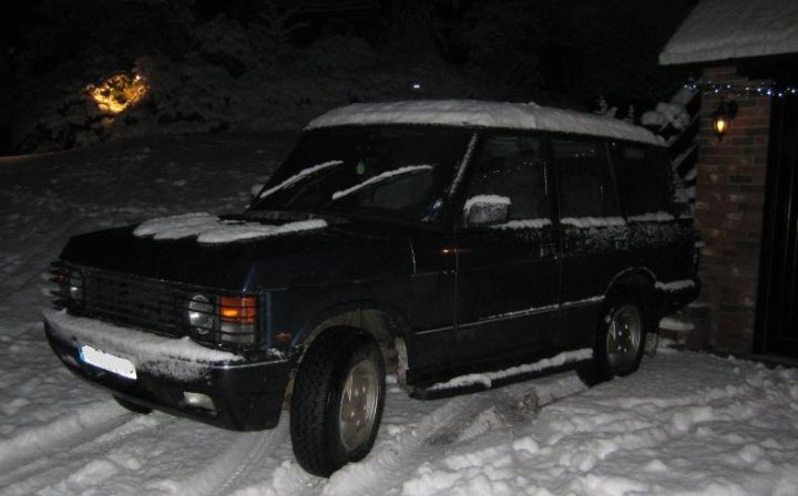 Pistonheads - The image depicts a black vehicle partially covered in snow, suggesting a snowy environment. The roof of the vehicle is heavily dusted with snow, indicating recent snowfall or the vehicle being parked in a location with significant snow accumulation. The phrase "The picture is too dark" suggests that the photo could be underexposed, which might give the vehicle and its surroundings a somewhat dark appearance. The setting seems to be a residential area, as indicated by the presence of a brick wall in the background, which might be part of a house or fence. Finally, there's an element of melancholy in the phrase "The picture is too dark," which could convey a sense of sadness, loneliness, or isolation in a snowy environment.