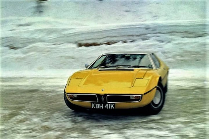 Old time supercars - Page 2 - Supercar General - PistonHeads - The image is a photograph of a yellow sports car with distinctive wedge-shaped headlights, parked on an icy surface. The car has a license plate visible in the front. There are no people or other vehicles nearby, and the surroundings suggest cold weather conditions, possibly during winter, given the frozen landscape. The style of the photograph is candid, capturing the car from a slight angle that accentuates its design features.