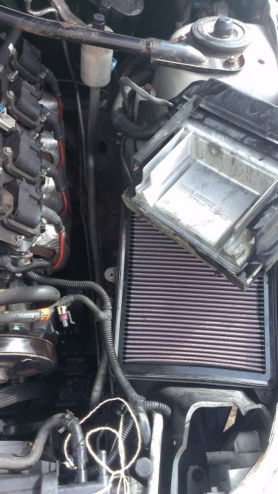 Air con leak - Page 1 - HSV & Monaro - PistonHeads - The image showcases the underside of a car where the engine is located. We can see the various fluid pipes and other components. In the foreground, there's a radiator grille with some visible fluid stains. Behind it, exposed cables and electrical connectors suggest that some maintenance or repair work might have been performed. The photo is quite detailed and gives a comprehensive view of the complex mechanical systems beneath a car's hood.