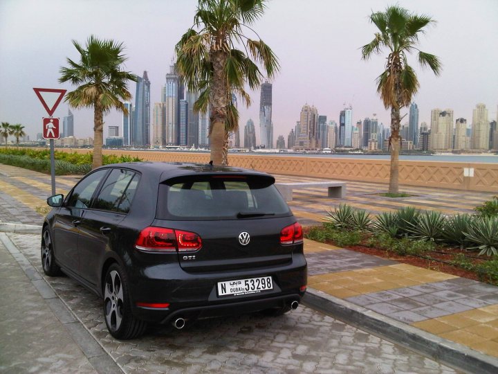 Gti Bought Pistonheads - The image presents a cityscape viewed from a coastal road. On the left side of the frame, a black compact car is parked by a sidewalk. The car is a four-door model and its rear end is visible with a European-style license plate. Behind the car, there's a park area with palm trees and a well-maintained grass lawn.

In the background, a city skyline stretches across the scene, ranging from the foreground all the way to the horizon where the city buildings fade into the sky. The city block is organized into an orthogonal grid structure, indicative of a planned urban design.

The image captures a sunny day with clear skies, as evidenced by no visible clouds and sunlit conditions. The sway of the palm trees suggests a gentle sea breeze, adding to the pleasant outdoor environment.

The style of the photograph seems to capture a travel moment, perhaps from the perspective of someone exploring the city or its coastline. The focus of the photograph is not on the car, but rather on the contrast between the urban and natural elements of the scene, and the hazy, possibly misty, sky that gives an atmospheric backdrop to the cityscape.