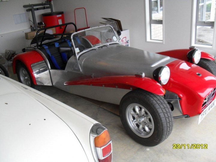 A red motorcycle parked in a parking space - Pistonheads - The image shows an exotic silver and red convertible car, either a vintage or a reproduction, parked in a room with a concrete floor. The car appears to be in good condition, with a shiny exterior and visible silver undercarriage. There are two black seats visible through the car's convertible top. In the background, there are some items, including what looks like a cardboard box and a recycling bin. The date stamp in the bottom right corner indicates that the photo was taken on 23rd November 2012. The style of the image is a standard, non-panoramic photograph taken in an indoor setting that focuses on the car.