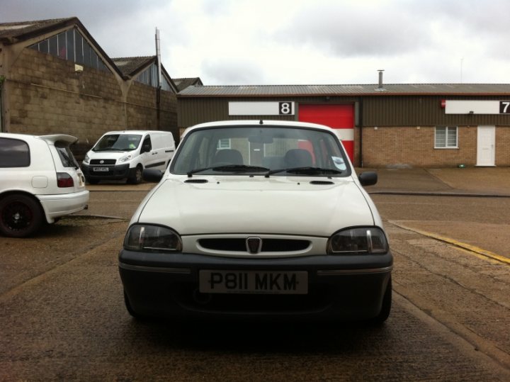 New Car Sneak Preview - Page 1 - East Anglia - PistonHeads - The image presents a serene day under a cloudy gray sky. Parked in a parking lot bathed in the soft light of daytime, a small white car with black accents catches the viewer's eye. The car is positioned in the foreground, ready to leap into motion at any moment. 

In the background, a red brick building adds a touch of color to the scene. A door bearing the number 8, and another with the number 7, can be seen on the building, perhaps suggesting the presence of apartments or offices. 

The absence of people in the image gives it a tranquil atmosphere, as if everyone has stepped away momentarily, leaving the car and the building as the main subjects of this peaceful tableau. The relative positions of the car and the building suggest that the car is parked closer to the camera, whereas the building is slightly further away. 

This image captures a moment of calm and stillness, with the car quietly waiting, and the building standing solid and stable under the cloudy sky.