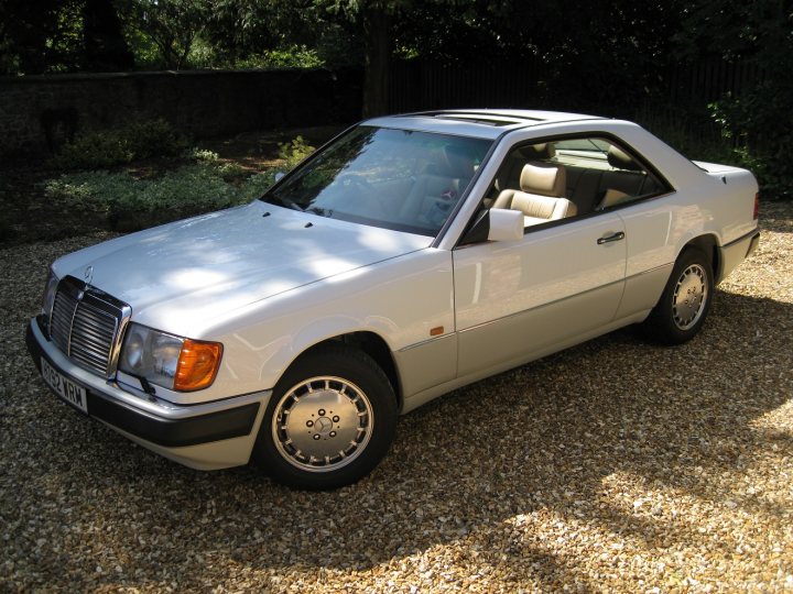 Best smoker barges 1-5 large [vol8] - Page 431 - General Gassing - PistonHeads - This image captures a white classic convertible car parked on a gravel driveway. The car is facing us, showcasing its sleek design and the convertible top is down, revealing the interior. The vehicle is positioned up on a gravel surface, with the headlights pointing towards the camera. The car's vintage charm is accentuated by the contrast between the white body and the natural gravel background.