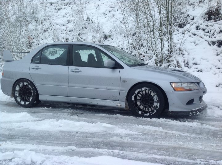 New to the forum,so posting a few pics of my car. - Page 1 - South Wales - PistonHeads - The image showcases a silver-colored car parked on the side of a snowy road. The car is positioned at an angle, with the front and side of the vehicle visible. It's covered in a layer of dirty snow, suggesting that it has been stationary for some time. The road itself is also covered in snow, indicating that the photo was taken during winter. The car's sleek design, typical of cars made in the late 90s to early 2000s, is accentuated by the snow-covered surface. The background reveals a line of trees, which are also dusted with snow.