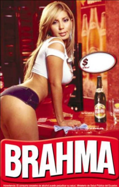 Marian Sabate - This image features a woman in an advertising context. She has long blonde hair and is wearing a white crop top and blue jeans. The woman is leaning over a bar top, suggesting a relaxed or flirtatious pose. To the right, there's a bottle of beer with the label obscured and a dollar sign appearing to be dissolving into the beer. The background has a blurred aesthetic, with warm colors contributing to the overall image. There's a text banner across the image that seems to be part of an advertisement, but the text is not fully legible.