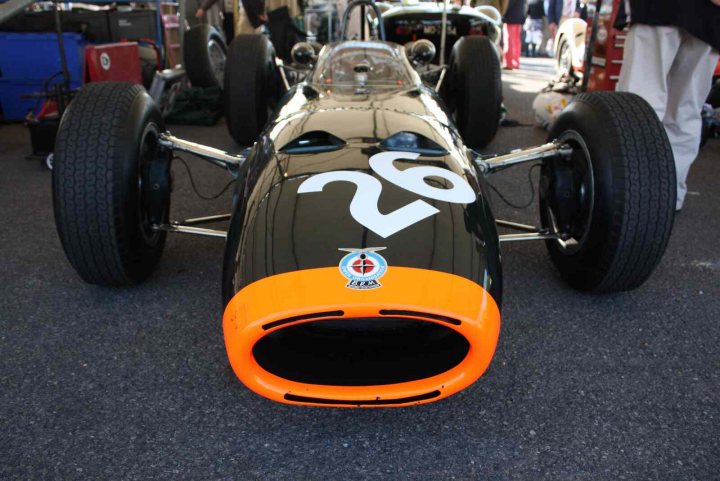 Revival images - Friday  - Page 1 - Goodwood Events - PistonHeads - The image showcases a vintage racing car prominently in the foreground, with a numerical '26' emblazoned on the side. The car's body and vintage detailing indicate it's a relic of an earlier racing era. In the background, other cars and people can be glimpsed, suggesting this might be an exhibition or event related to automotive history. The ground is paved, and the setting appears to be an open, outdoor area, possibly a museum or showroom dedicated to classic automobiles.