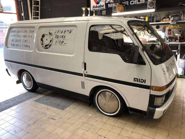 A white van parked in front of a building