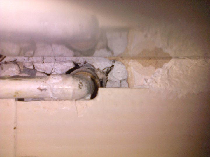 Do you need a 22mm gas pipe for a non-combi boiler? - Page 2 - Homes, Gardens and DIY - PistonHeads - The image captures a close-up view of a dirty, broken wall. The wall has visible chunks and cracks, indicative of its need for repair. A piece of old, rusted metal is embedded in the wall, adding to the overall state of disrepair. Adjacent to the metal, there appears to be some form of insulation or padding. The scene suggests a corner of a building, possibly in an industrial or older building context. The focus on the metal and rough wall texture suggests a photo taken to highlight these elements.