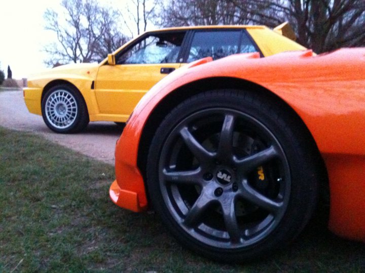 Seconds Endulge Pistonheads - The image showcases a vibrant scene of three sports cars parked side by side on a verdant grassy area. Dominating the picture are two striking cars: a bright yellow Porsche 911 on the left and a sleek, fiery orange Ford GT on the right. The Porsche, with its classic wedge shape and grande grille, is tilted slightly towards the left side of the image, offering a profile view. The Ford GT, on the other hand, faces the viewer directly, its long nose and short rear end reflecting the design elements of this iconic supercar. The third car, a black Audi, is parked off to the right, subtly positioned behind the yellow Porsche, creating an attentive scene ready for a spin.