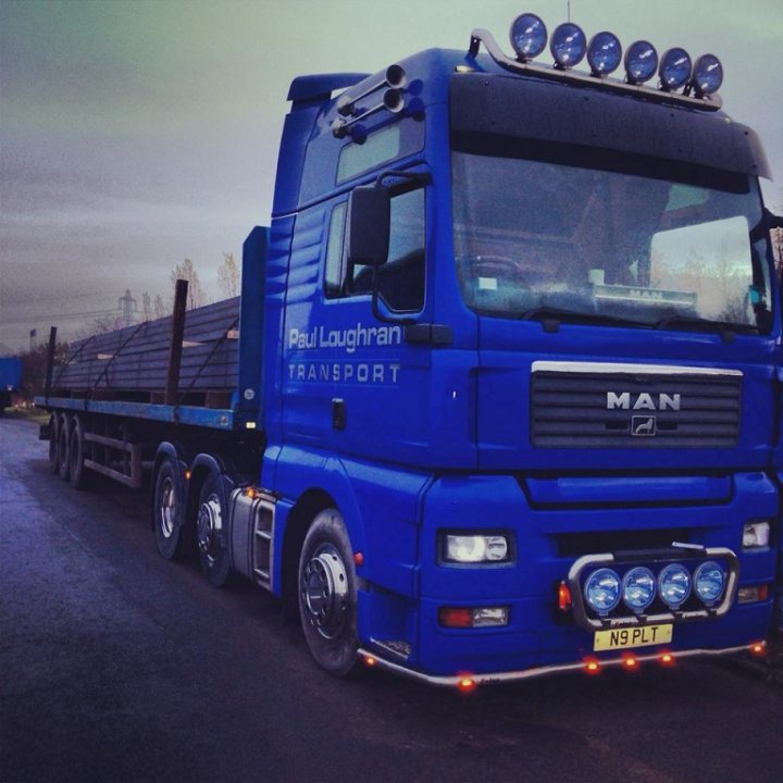 Approximate Costs to Respray a Lorry - Page 1 - Commercial Break - PistonHeads - The image features a large, blue semi-truck. The truck prominently displays the number '9', suggesting it might be part of a fleet or have a designated role. The back of the truck is fitted with red lights, adding to its presence on the road. There's a notable amount of the tire and vehicle's rear lights visible, indicating the rear view of the truck. The truck is parked on what appears to be a quiet, possibly rural, road under overcast skies.