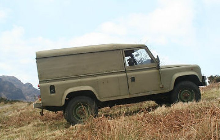 £750 Land Rover, what could possibly go wrong? - Page 1 - Readers' Cars - PistonHeads - The image captures a vintage green Ford Bronco, an SUV with a distinct square shape, parked precariously on a steep grass and shrub terrain. The vehicle's open roof adds to its rugged charm, revealing the sky above. The Bronco is slightly tilted, suggesting that it has been parked haphazardly on the uneven terrain. The vast, scenic landscape provides a beautiful backdrop, setting the stage for an outdoor adventure.