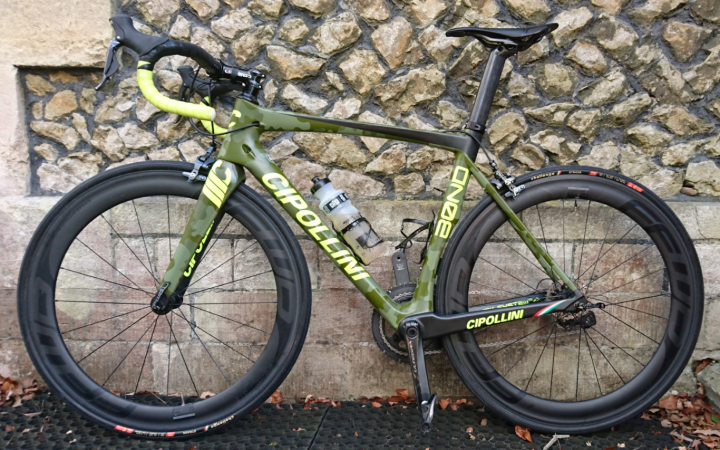 Anybody any experience of Cipollini? - Page 2 - Pedal Powered - PistonHeads - The image showcases a Cipollini bicycle, a professional-grade road bike, parked against a stone wall. The bicycle's frame is a vibrant shade of green with yellow and white accents, a distinctive feature of the Cipollini brand. Its tires are black, and there's a water bottle attached to the frame, ready for a ride. The bike is leaning slightly to one side, suggesting its lightweight construction and the rider's readiness to engage in an active pursuit. The overall scene conveys a sense of potential energy, anticipating a cycling adventure.