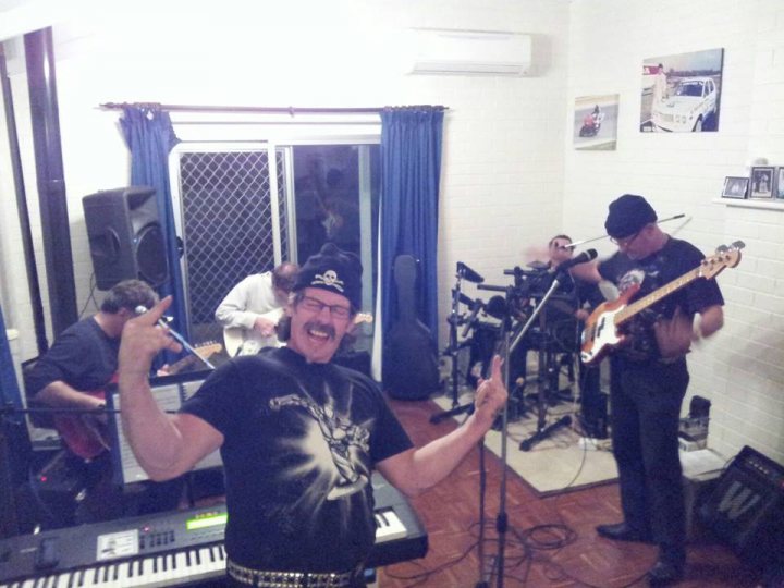 Partaaay time - Page 1 - Australia - PistonHeads - In the center of a lively music studio, a man with a flair for style is passionately playing an electric guitar. He is pointing at someone he seems to be engaging with, possibly as part of their performance. The studio is bustling with activity, with multiple musicians around him, contributing to the vibrant and creative atmosphere.