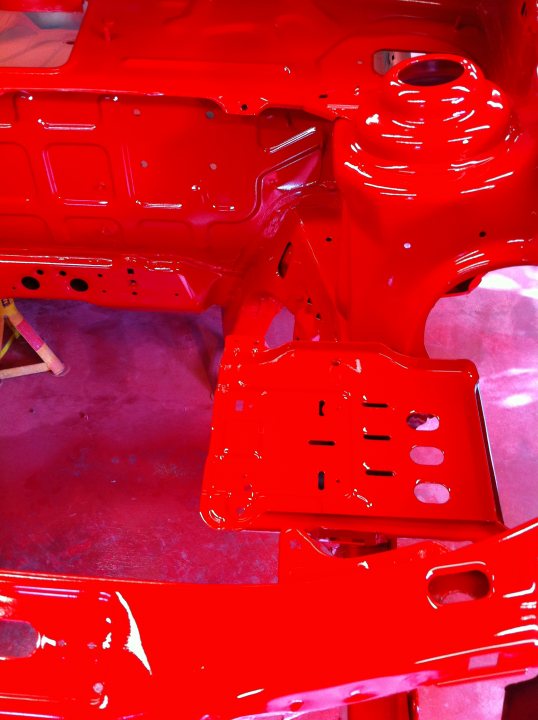 Fiesta RS Turbo Restoration - Page 6 - Ford - PistonHeads - The image depicts a blurry view of the engine bay of a red vehicle. The focus is on the vehicle's engine, with the red engine cover prominently visible. However, the engine cover appears to be absent, exposing the engine parts inside. The overall scene suggests an ongoing process of vehicle maintenance or restoration.