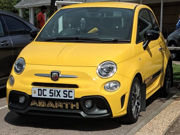 What C124PPY personalised plates have you seen recently? - Page 479 - General Gassing - PistonHeads - The image showcases a vibrant yellow Fiat Abarth car, which is parked on a street. The car is positioned in front of a building with a white facade. It's worth noting that the registration plate of the car displays "DC Six S", indicating it may be a modified or special edition model. The overall scene suggests an urban setting during daylight hours.