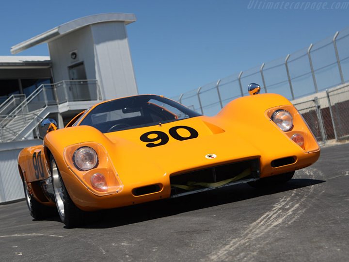 A red and white fire hydrant sitting on the side of a road - Pistonheads - In the image, a striking yellow race car is the center of attention. The car is adorned with the number 90 prominently displayed on its side, and the iconic badge of Porsche on the hood, signifying its identity. It's parked on a race track, under the clear blue sky. In the background, a building can be glimpsed, perhaps part of the race track facility. The setting is dynamic, with the race car poised as if ready to zoom off into the distance.