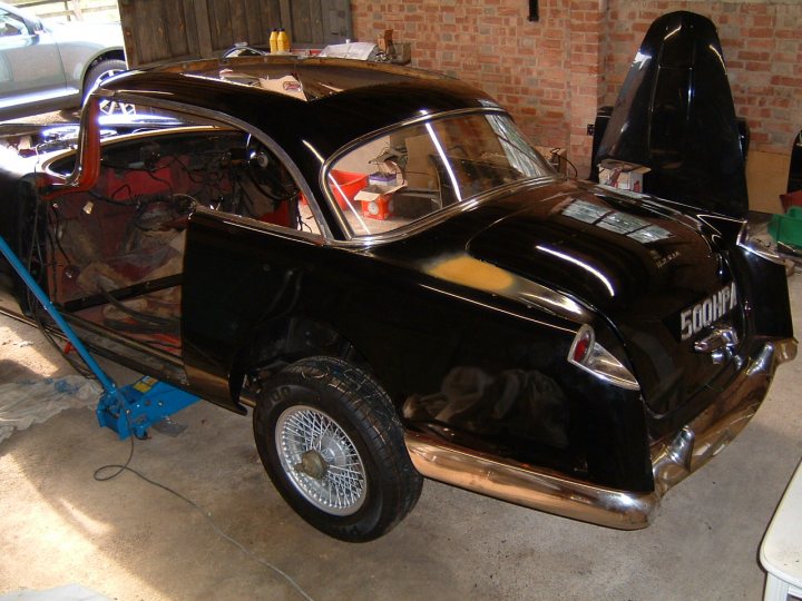 Webasto sunroof - fitting in 2021 to a classic - Page 3 - Classic Cars and Yesterday's Heroes - PistonHeads UK - The image showcases a black vintage car, which appears to be undergoing restoration. It is parked inside a building, possibly a workshop or garage, where various tools and equipment can be seen in the background. The car's hood is open, revealing its engine, suggesting that it is currently being worked on. The overall scene suggests a meticulous process of maintaining and preserving the classic vehicle.