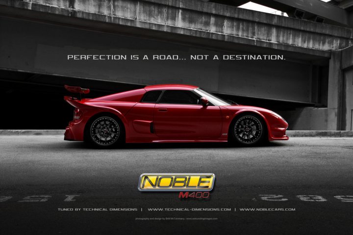 M400 ride height - Page 1 - Noble - PistonHeads - This is a promotional image featuring a red sports car positioned under an overpass. The text overlay on the image conveys a motivational message, "Perfection is a road... not a destination." The car is sleek with a curved body design indicative of performance and speed. The setting appears to be a dark, likely urban night-time environment, enhancing the car's lustrous contrast. The logo "NOBLE" is prominently displayed at the bottom of the image.