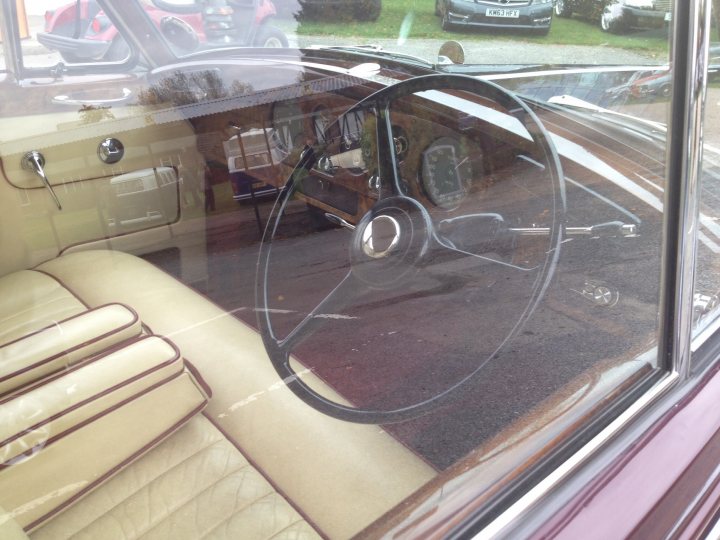 A view of a mirror from a car window - Pistonheads - The image showcases a classic car interior through its window. The focus is on a steering wheel with a minder, indicating a vintage car design. The dashboard is visible, adding to the overall nostalgic feel.