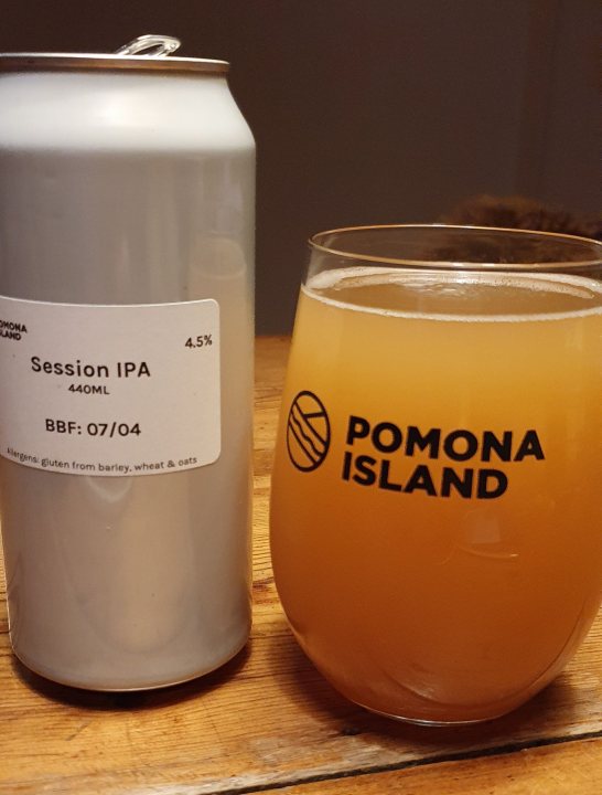 Craft beer - Page 6 - Food, Drink & Restaurants - PistonHeads - The image depicts a casual setting with a can of beer and a glass partially filled. On the table, there's a white label affixed to the beer can that reads "Session IPA 4% ABV". Next to the beer can is a clear label stating "BFG 06/21 8:35 AM - BFG", suggesting that the beer was brewed and canned at this specific time. Behind these items, there's a framed picture of a beautiful beach scene with a clear blue sky and white clouds, which adds to the overall relaxed atmosphere. A cup of what appears to be coffee is also present on the table. The image seems to capture a quiet moment at a brewery or perhaps a home-brew setup.