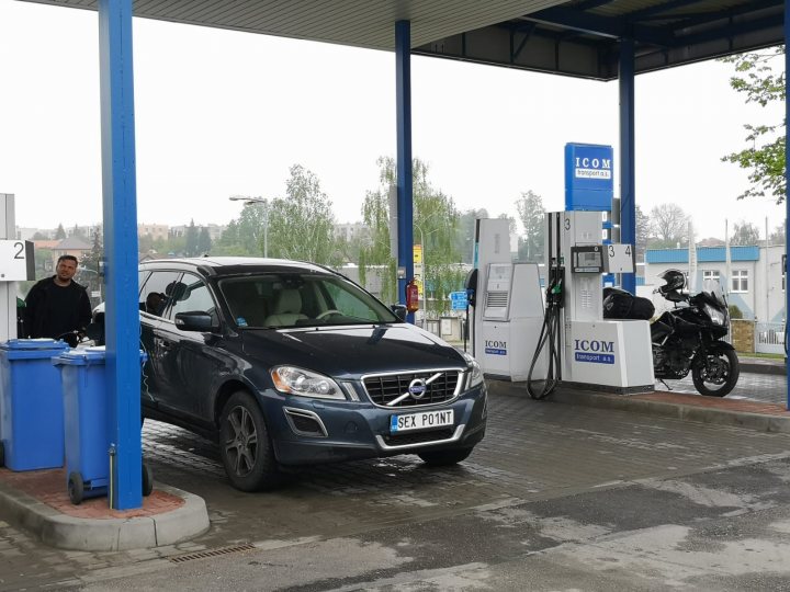 What C124PPY personalised plates have you seen recently? - Page 479 - General Gassing - PistonHeads - The image depicts a scene at a gas station. A car, specifically a blue Volvo, is parked at the gas pump, indicating that it's currently being refueled. The gas station itself appears to be an automated one, as suggested by the presence of an ATM-like structure next to the car. There are two individuals present in the scene; however, their activities are not clearly discernible from the image. The surroundings suggest a typical day at the gas station, with the ground appearing wet and the sky overcast.