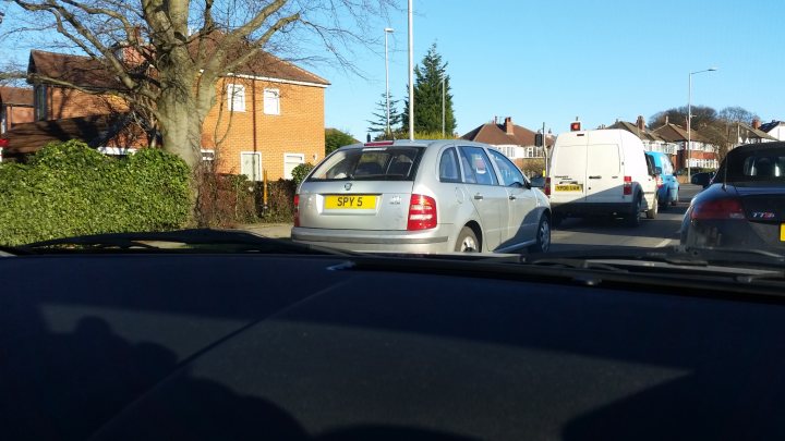 The 2015 Yorkshire Spotted Thread - Page 7 - Yorkshire - PistonHeads - The image captures a typical urban scene in which two cars are stopped at a traffic light. One of the cars is silver and positioned in the back of the frame, while the other is closer to the viewer and appears to be a red van. The cars rest in front of a row of houses, one noticeable for having a white car parked in its driveway. The road curves subtly to the right, partially obscured by the hood of the red van, suggesting that the photo was taken from the passenger's side. The sky is clear, indicating a sunny day.