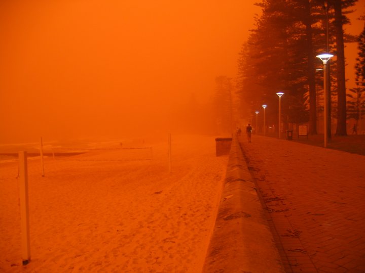 Pictures that capture life in 'Straya - Page 1 - Australia - PistonHeads - The image captures a vivid scene at a beach during a time of substantial fog. The fog is so thick that the horizon seems to blend into it. The beach appears to be empty, deserted by the mysterious orange hue that tints the scene. Despite the eerie and surreal atmosphere created by the fog, a small figure can be spotted in the distance, adding a sense of scale to the vast expanse of the beach. The lighting conditions suggest this could be either early morning or possibly late afternoon when the sun is near the horizon.