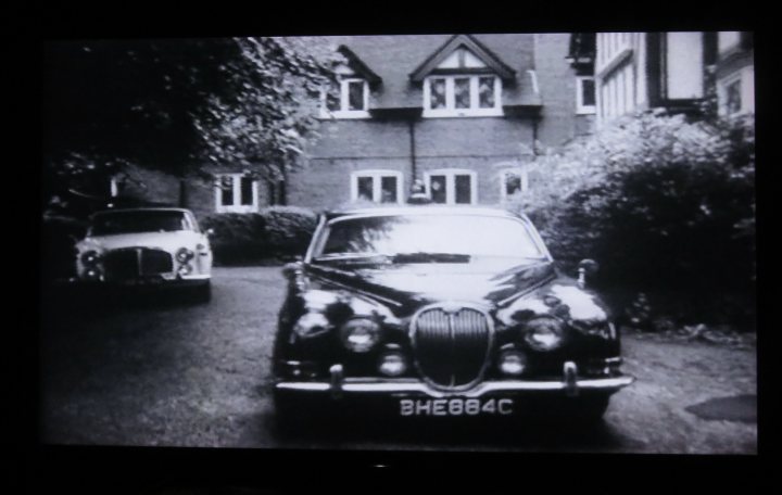 Pistonheads - The image shows a vintage car, possibly a Jaguar or similar model, parked in front of a house. It is displayed on a large screen that occupies the majority of the image. The setting appears to be outdoors during the daytime, as indicated by the natural lighting and the presence of trees in the background. The style of the photograph seems old-fashioned, which aligns with the car's appearance suggesting it might have been taken some time ago.