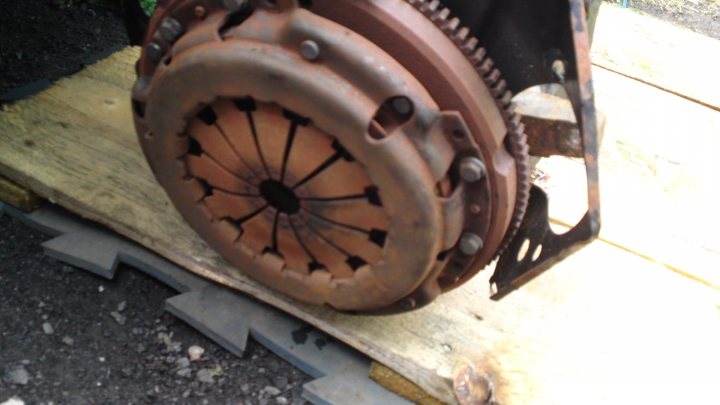 A close up of a motorcycle on a train track - Pistonheads - The image captures a close-up view of an old machinery or vehicle component, specifically a piece of metal with rusted mechanisms. This piece of metal appears to be a metal belt or pulley due to its circular shape and textured surface. The item is placed on what could be a scrap wooden pallet, suggesting a potential recycling or maintenance context. The rusting indicates age and exposure to the elements.