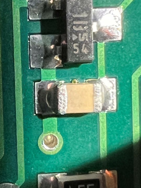 Electronic tech help please - Page 1 - General TVR Stuff & Gossip - PistonHeads UK - The image shows a close-up view of a printed circuit board (PCB) with electronic components. The PCB appears to be part of a larger device, possibly an electronic module or chipset, as suggested by the presence of interconnecting wires and pins that could be for socketing or testing purposes. There are integrated circuits (ICs) visible on the board, which are essential for processing and communication in modern electronics. The image has a high level of detail, revealing the intricate design and assembly of such circuit boards, a testament to the complexity and precision involved in electronic manufacturing.