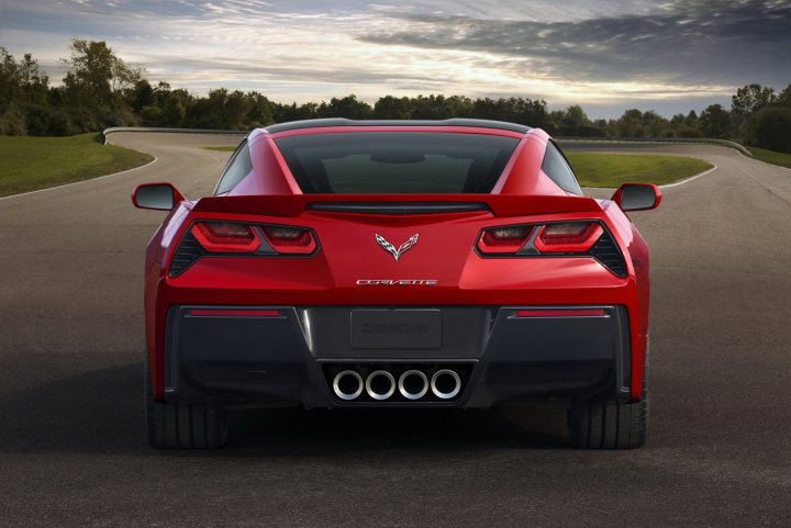 A red car is parked in a parking lot - Pistonheads - The image features a luxurious sports car with a prominent rear spoiler. It's a high-resolution photograph showing the back end of the car, taken on a track with a sweeping curve in the background. The vehicle is distinctly a Chevrolet Corvette, as indicated by the badge and emblem on the car's body and the engine cover. The vehicle has an aggressive stance and the engine cover is emblazoned with the word "Callaway," suggesting that it has been modified with a high-performance upgrade.