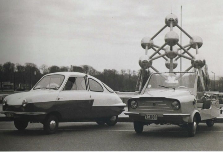 1958 Nobel 200 - Page 1 - Classic Cars and Yesterday's Heroes - PistonHeads - The image is an evocative black and white photograph capturing a moment in time. Dominating the frame is a large, intricate sculpture featuring a lattice of spheres that together form a dandelion-like structure towering above the scene. The sculpture appears to be crafted with precision and attention to detail, suggesting an engineering or architectural theme.

In front of this towering structure is a vintage car, its design reminiscent of the 1960s. The car is clean and well-maintained, reflecting a bygone era. Parked behind this classic car is another small vehicle, carrying a more utilitarian purpose. The juxtaposition of these two vehicles with the modern and yet vintage feel of the sculpture creates a contrast that is both striking and engaging.

The exposition against the sculpture suggests that this might be an art installation or a public event of cultural significance. The overall composition and the monochromatic palette of the image lend a timeless quality to the scene, inviting contemplation about the past and present coexisting in the shared space. The vehicles, the sculpture, and the backdrop of what could be a rural countryside all contribute